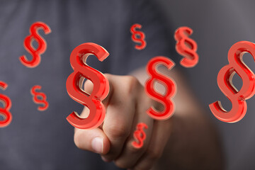 Abstract image of red paragraph symbols floating, representing legal concepts and law.