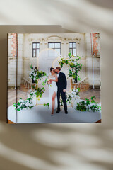 a closed photo book with wedding photos on a white table