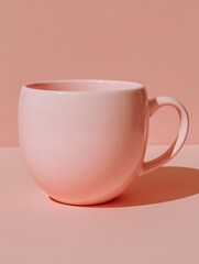 A simple pink cup is prominently displayed against a matching pink background, highlighting its smooth curves and minimalist design. The soft color palette creates a serene and calming atmosphere.