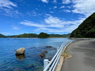 Japan, Nagasaki Prefecture, Kamigoto Islands, Nakadōri Island scenic coastline with clear turquoise sea and floating fish farms