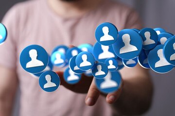 Image depicting a hand interacting with numerous social media profile icons, symbolizing networking...