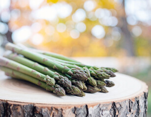 Close up shots of bunch of green asparagus. displayed on wooden board. 