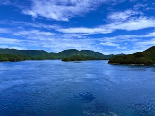 Japan, Nagasaki Prefecture, Kamigoto Islands, Nakadōri Island scenic coastline with clear turquoise sea and floating fish farms