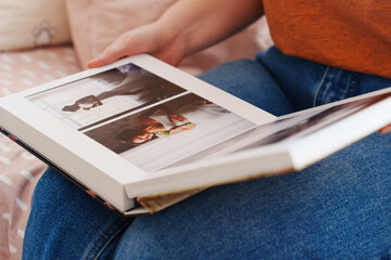 Female hands flipping through a photo book with wedding photos