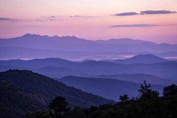 Fototapeta premium Breathtaking mountain range silhouette with pastel sunset hues offers a serene and calming landscape view