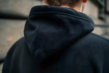 Simple Hoodie's Detail: A close-up captures the stylish design, focusing on the hood's texture, revealing the details and construction of a classic hooded sweatshirt.