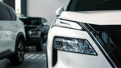 Sleek white car showcased in modern showroom, highlighting elegant design and advanced features,...