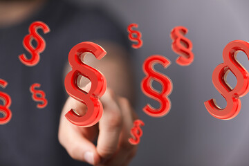 Red paragraph symbols floating, hand interacts.  Legal, law, justice, contract, agreement.