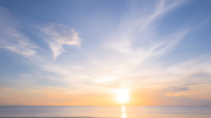 Sunset seascape with golden light spreading across a quiet waterline under a wide blue sky ideal for banners quotes and websites
