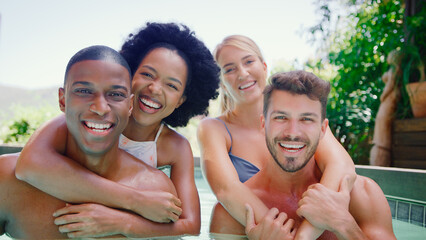 Group Of Smiling Multi-Cultural Friends On Holiday In Swimming Pool