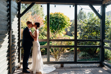 Beautiful and in love bride and groom kissing in the rays of the setting sun.