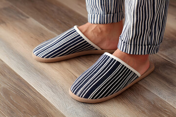 Cozy Comfort at Home:  A close-up shot of someone wearing comfy slippers, the striped design adds a touch of style to the relaxation.
