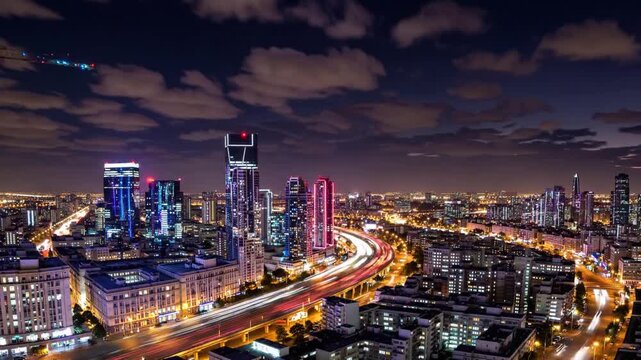 Urban development and transportation infrastructure are highlighted in Tel Aviv as day transitions into night, showcasing the city's dynamic energy and vibrant atmosphere