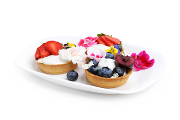 Sweet tartlets with berries and flowers isolated on white. Delicious dessert