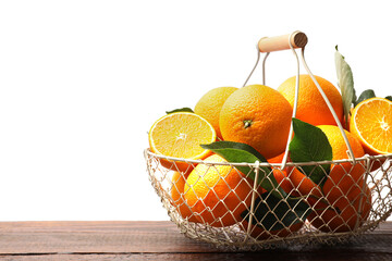 Juicy oranges and green leaves in metal basket on wooden table against white background. Space for...