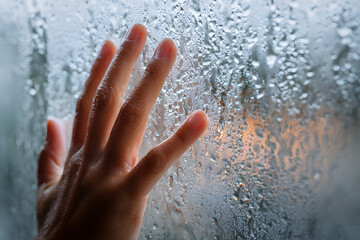 The Touching Droplets: A close-up shot of a hand gently touches a misted window, the blurred background hinting at a world beyond, offering a sense of connection.