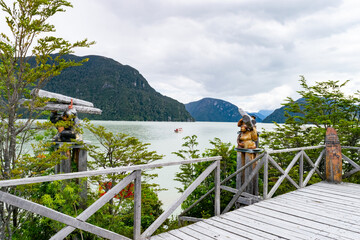 Wooden sculptures overlooking lake tagua tagua in chile's patagonia region