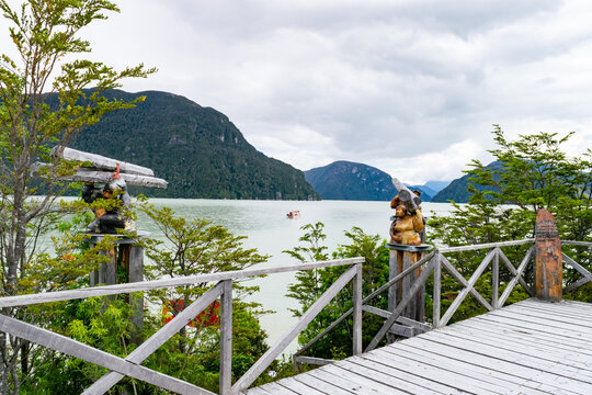 Wooden sculptures overlooking lake tagua tagua in chile's patagonia region
