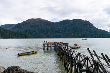 Wooden pier extending into tranquil waters of chilean patagonia