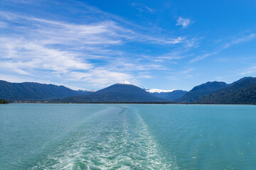 Motorboat sailing on reloncavi sound leaving wake in chile patagonia