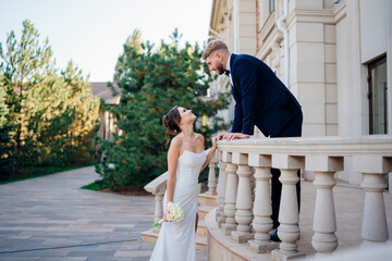 Happy and in love bride and groom on the balcony at the railing at the entrance 
