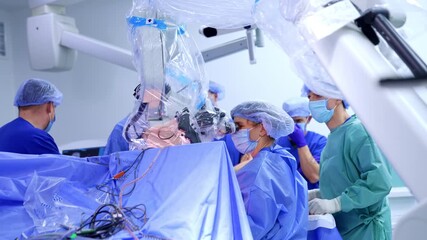 Diverse team of doctors working in the modern surgery room. Neurosurgeons look at microscope performing operation. - Powered by Adobe