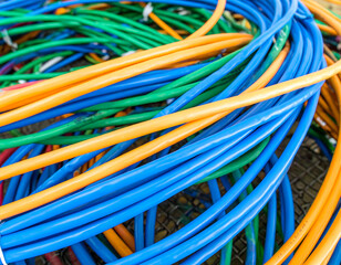 Tangled colorful cables in blue, green, and orange create a vibrant and abstract pattern.