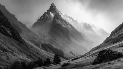 A vast mountain landscape showcasing jagged peaks and rolling valleys under an overcast sky Black and white