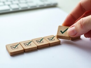 Work Progress Loading Bar with Checklist. A hand places wooden block with a checkmark into loading bar with 5 checkboxes, symbolizing progress, task completion, and project workflow.