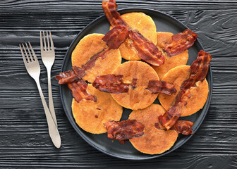 bacon pancakes drizzled with sirup on a plate
