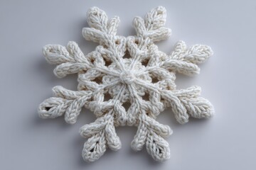 White crocheted snowflake resting on a white background, evoking cozy winter vibes and festive holiday spirit