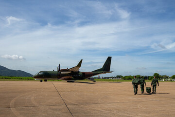 Aircraft Ground Prep, Soldiers walking with gear near a military transport plane on a runway,...