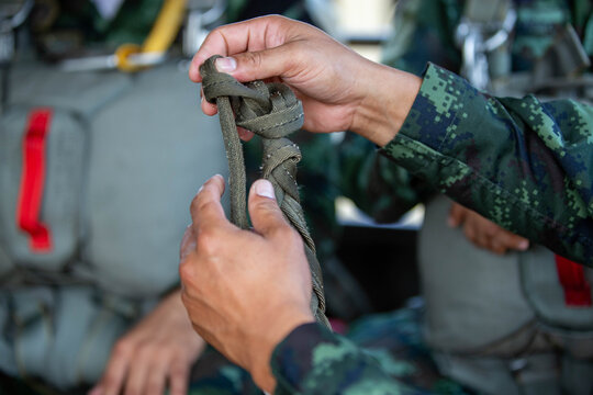 Tying knots, ropes, or straps used by soldiers or parachutists to secure or secure equipment, such as parachute cords or other equipment used in military training or missions.