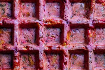 Background and texture of beetroot, zucchini, cheese and herbs waffle made with waffle maker, closeup, top view. Tasty vegetable waffles for eat