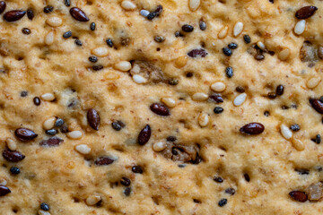 Background and texture of whole grain cookies made from flax, sesame and sunflower seeds, closeup, top view. Homemade healthy trendy cereal cookies with various seeds