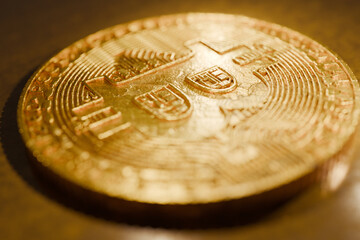 Close-up of a shiny golden Bitcoin lying on a reflective surface, symbolizing cryptocurrency, digital money, blockchain technology, investment, and modern finance. Gold coin. Digital finance