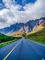 Fototapeta premium Vertical shot: N1 Highway in shadow, sunlit Du Toitskloof Mountains, South Africa