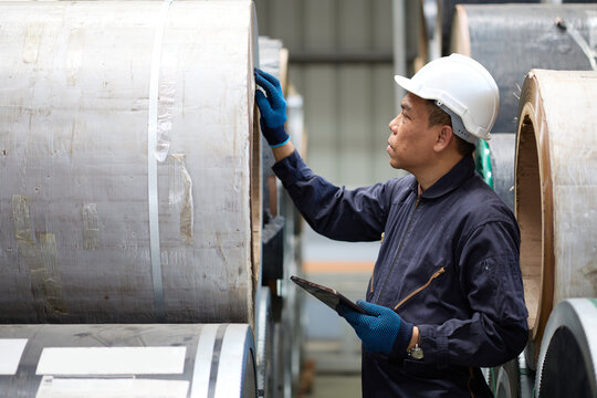 Technician or worker working on tablet and checking Sheet metal products in the factory
