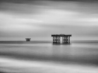 Black and white long exposure of abandoned cooling platforms on stilts off the coast at Sizewell,...