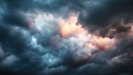 Naklejka premium A dramatic sky filled with dark, swirling clouds, illuminated by patches of light, creating a moody and atmospheric scene.