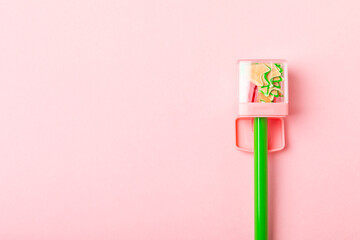 Pencil sharpener on bright colored background. Pencil and pencil shavings. Stationery. School...