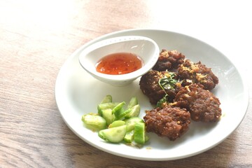 deep fried salty chop pork ball with garlic dipping sweet chili sauce and slice cucumber on plate