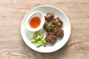 deep fried salty chop pork ball with garlic dipping sweet chili sauce and slice cucumber on plate