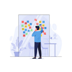 Man brainstorming on a glass board with sticky notes for business planning