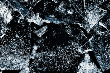 Broken textured ice. Crushed natural textured ice on a black background, close-up.