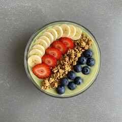 A vibrant smoothie bowl featuring sliced fruit, granola, and fresh blueberries.