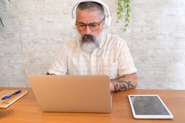 Man working on laptop with headphones.