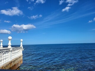 Blick auf das blaue Meer und den Himmel von einer Uferpromenade mit weißem Geländer in Bari,...