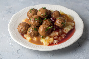 Köttbullar - Traditional Swedish meatballs with cream sauce, mashed potatoes, pickled cucumber, and lingonberry jam