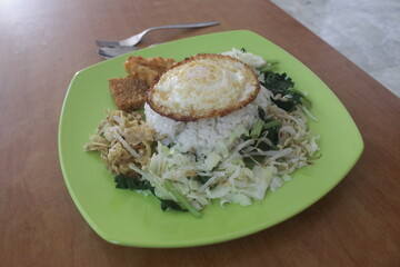 indonesia healthy traditional food named nasi pecel with warm rice vegetable fried egg and peanut sauce